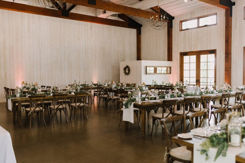 Farm table wedding reception with garlands of eucalyptus and greenery