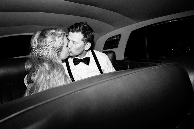 bride and groom exit in classic car