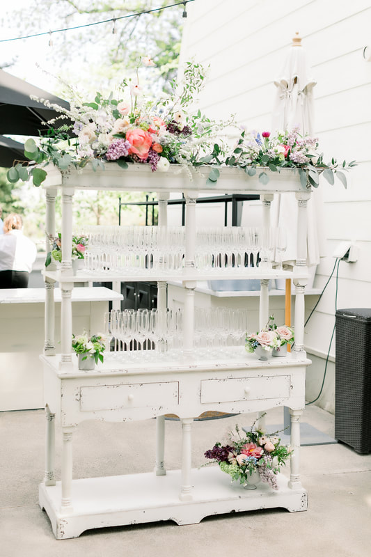 White vintage champagne bar with colorful flowers