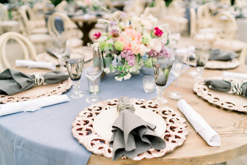Round wooden tables with dusty blue runners