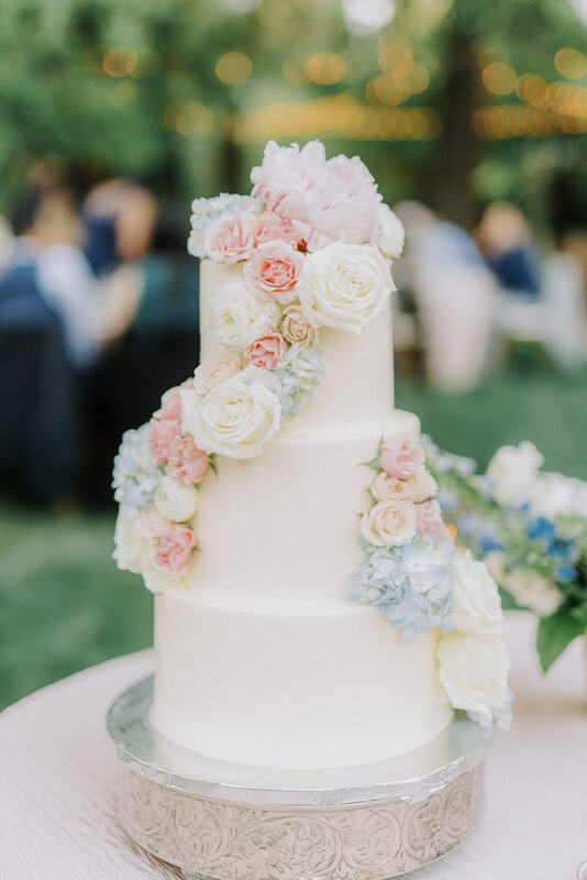 Three-tier wedding cake with fresh flowers