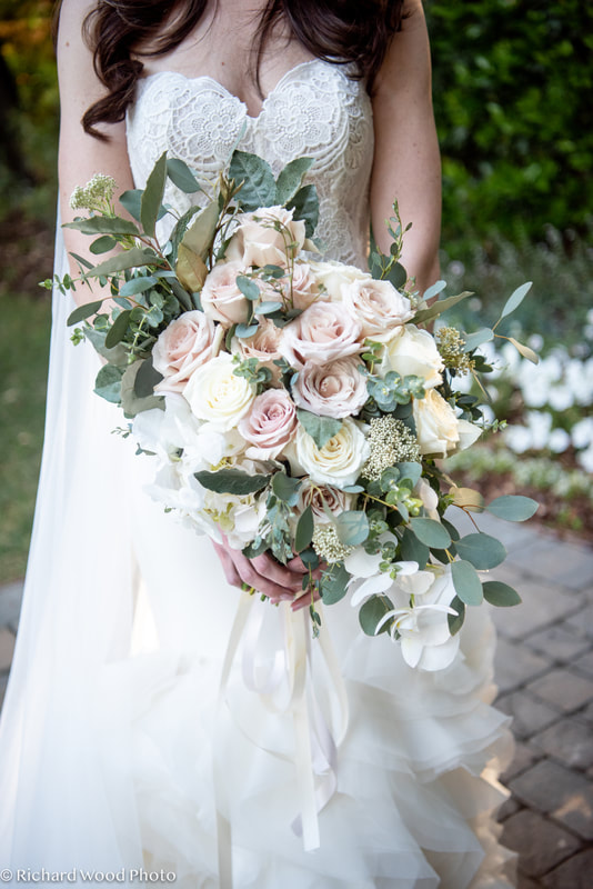 Bridal bouquet with mauve and ivory roses and draping eucalyptus