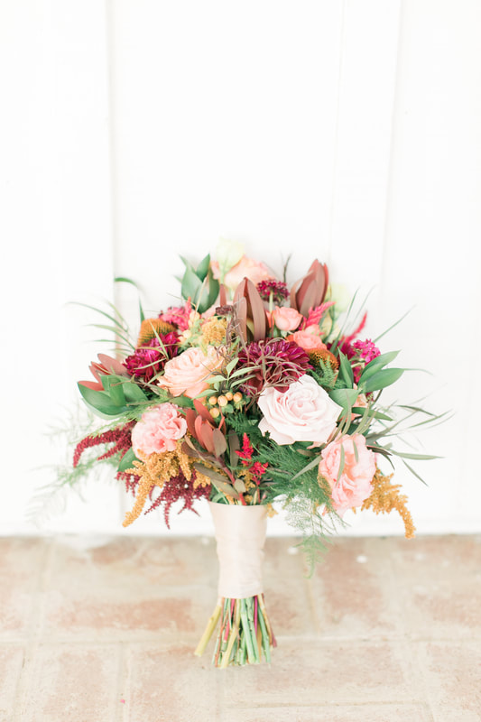 Colorful bridal bouquet with peonies, roses, protea and greenery