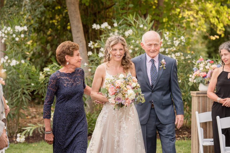 bride walking down the aisle with parents