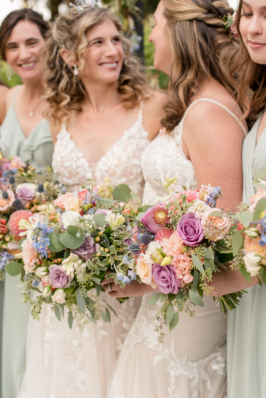 Pastel bridal bouquet with cream roses, hydrangeas, snapdragons, and blue flowers