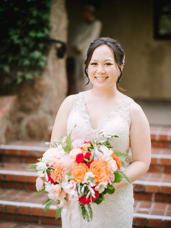 bridal bouquet with orange, red, and blush flowers