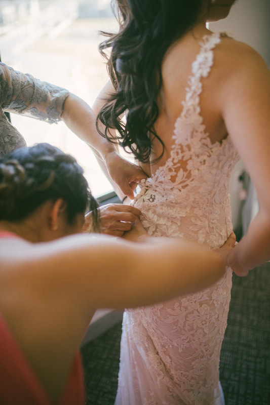 bride getting into her lace gown